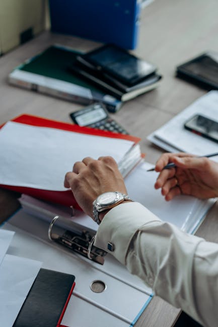 Person working at a desk taking a brief moment to stretch their arms